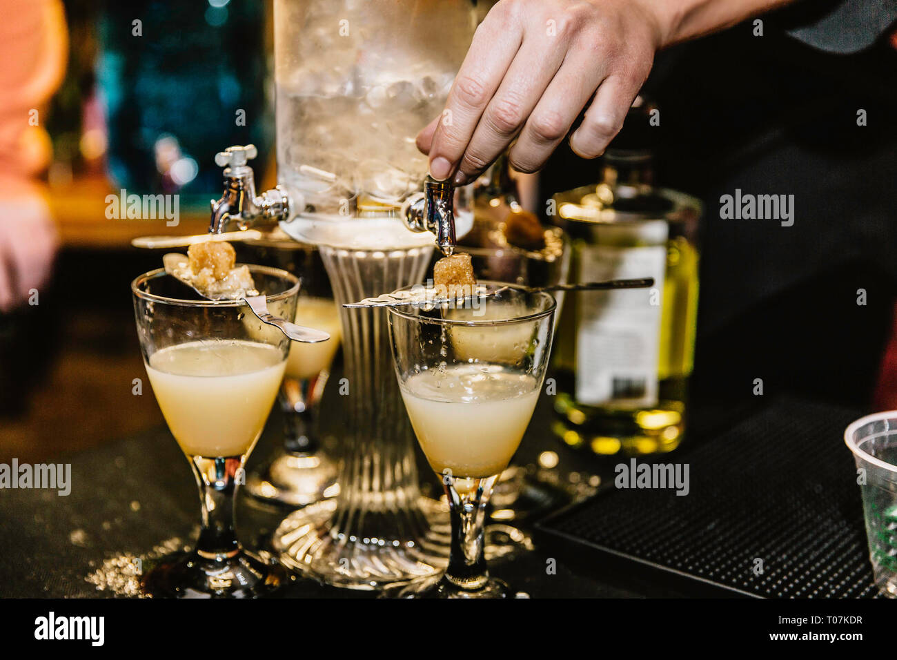 A bartender preparing cocktails mixed with absinthe at an event Stock Photo