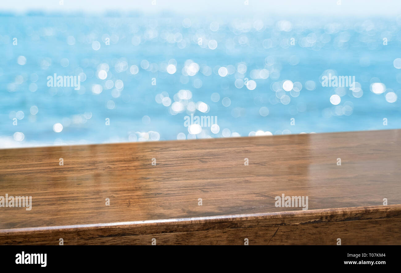 Empty Brown Glossy Wood Table Top With Blur Sky And Sea Boekh
