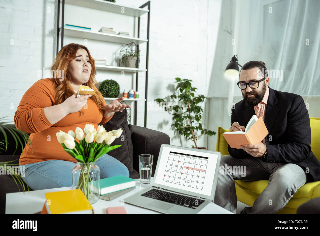 Serious bearded man making notes during consultation Stock Photo