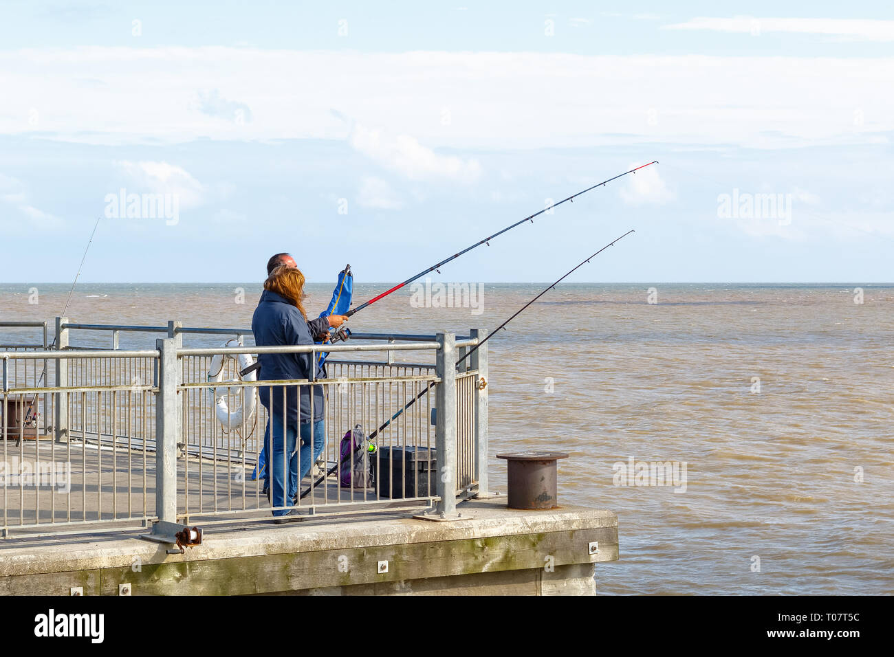Southwold, UK - September 10, 18 - People fishing with fishing rods on Southwold Pier Stock Photo