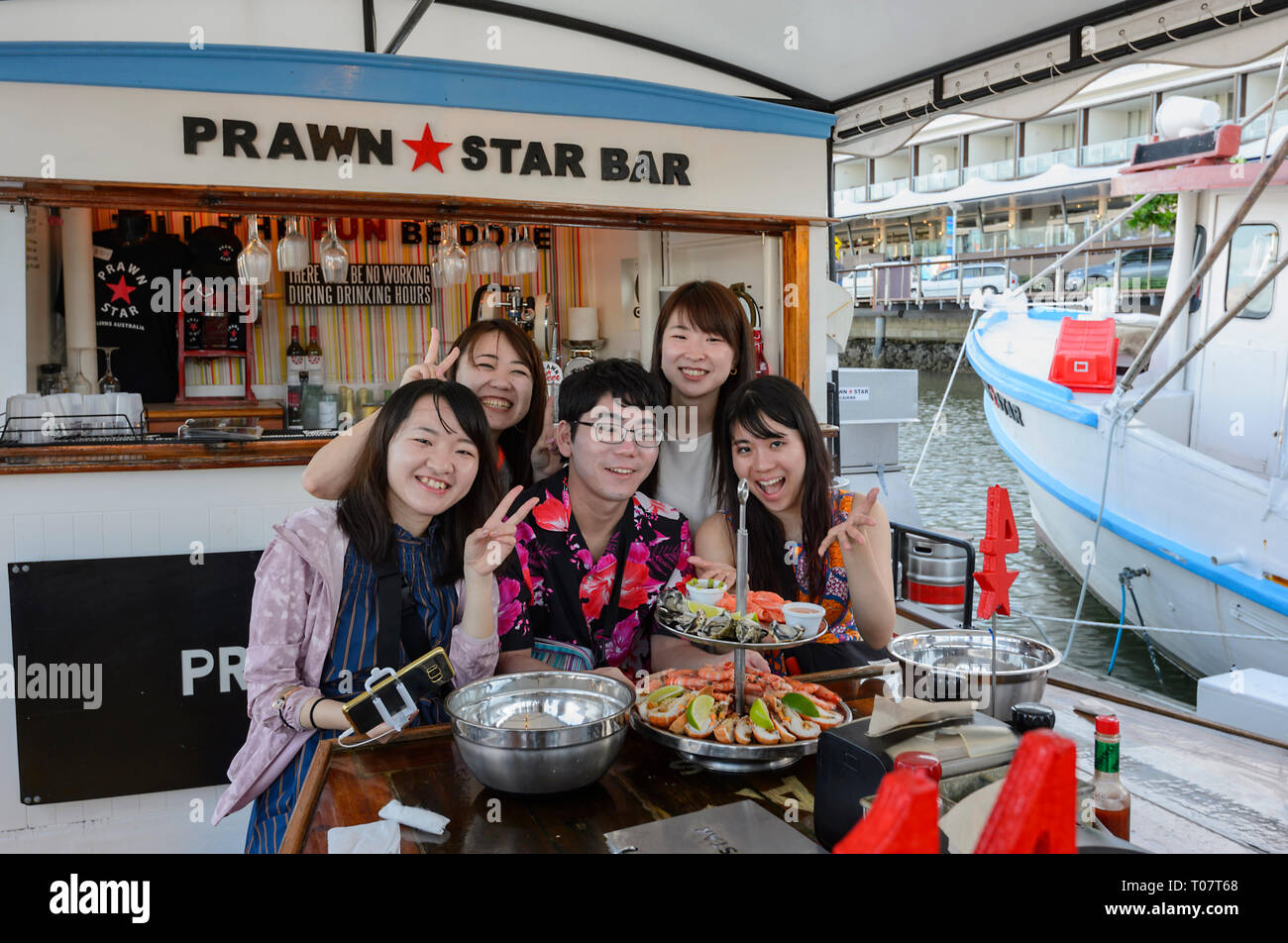 A group of Oriental visitors eating seafood on board the Prawn Star, Cairns, Far North Queensland, FNQ, QLD, Australia Stock Photo