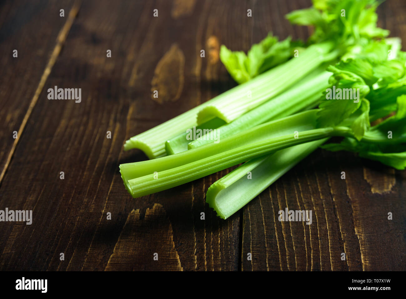 Fresh Celery stalks on dark wooden background Stock Photo
