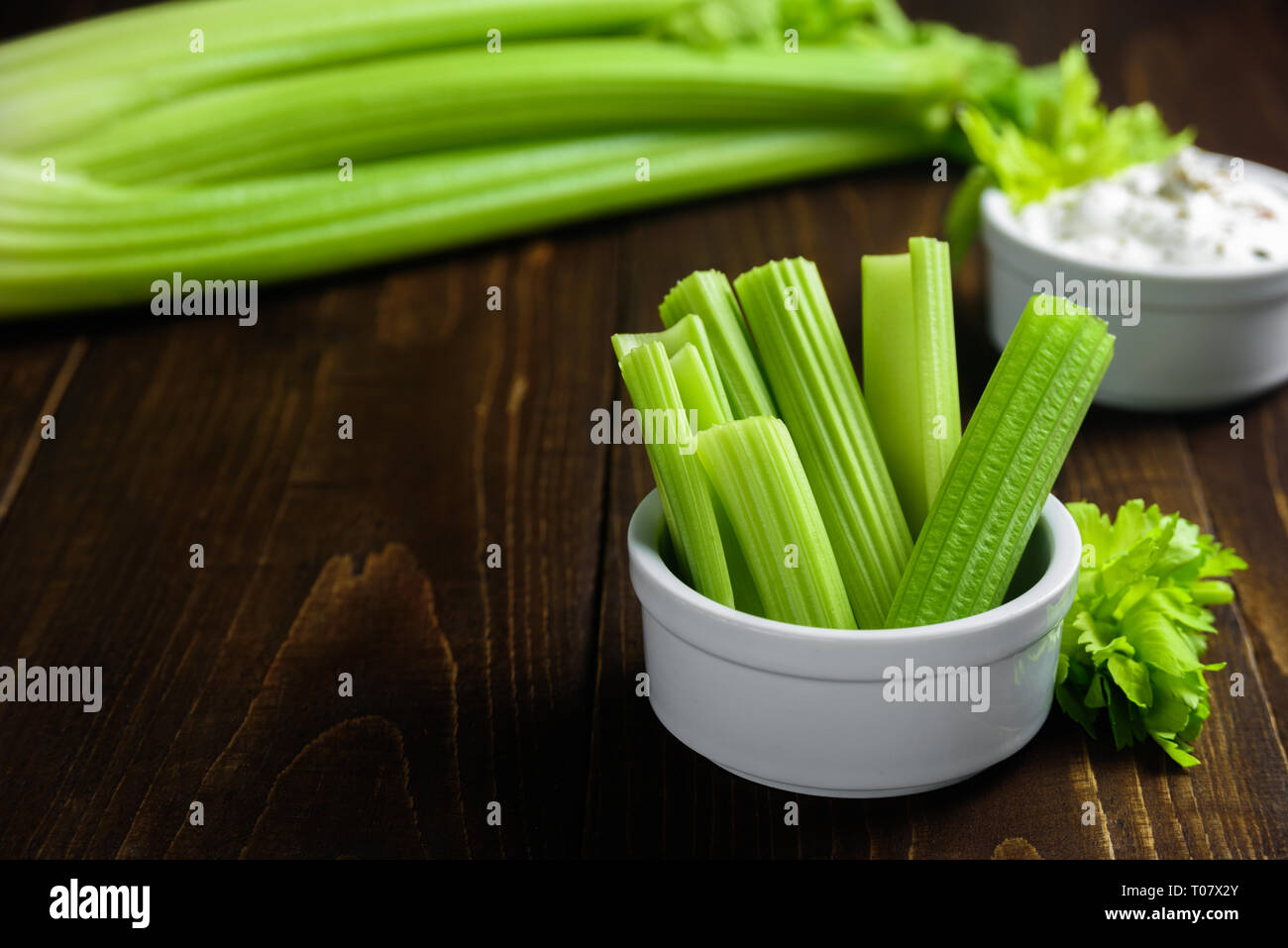 Celery sticks in ceramic bowl with greek yogurt sauce Stock Photo
