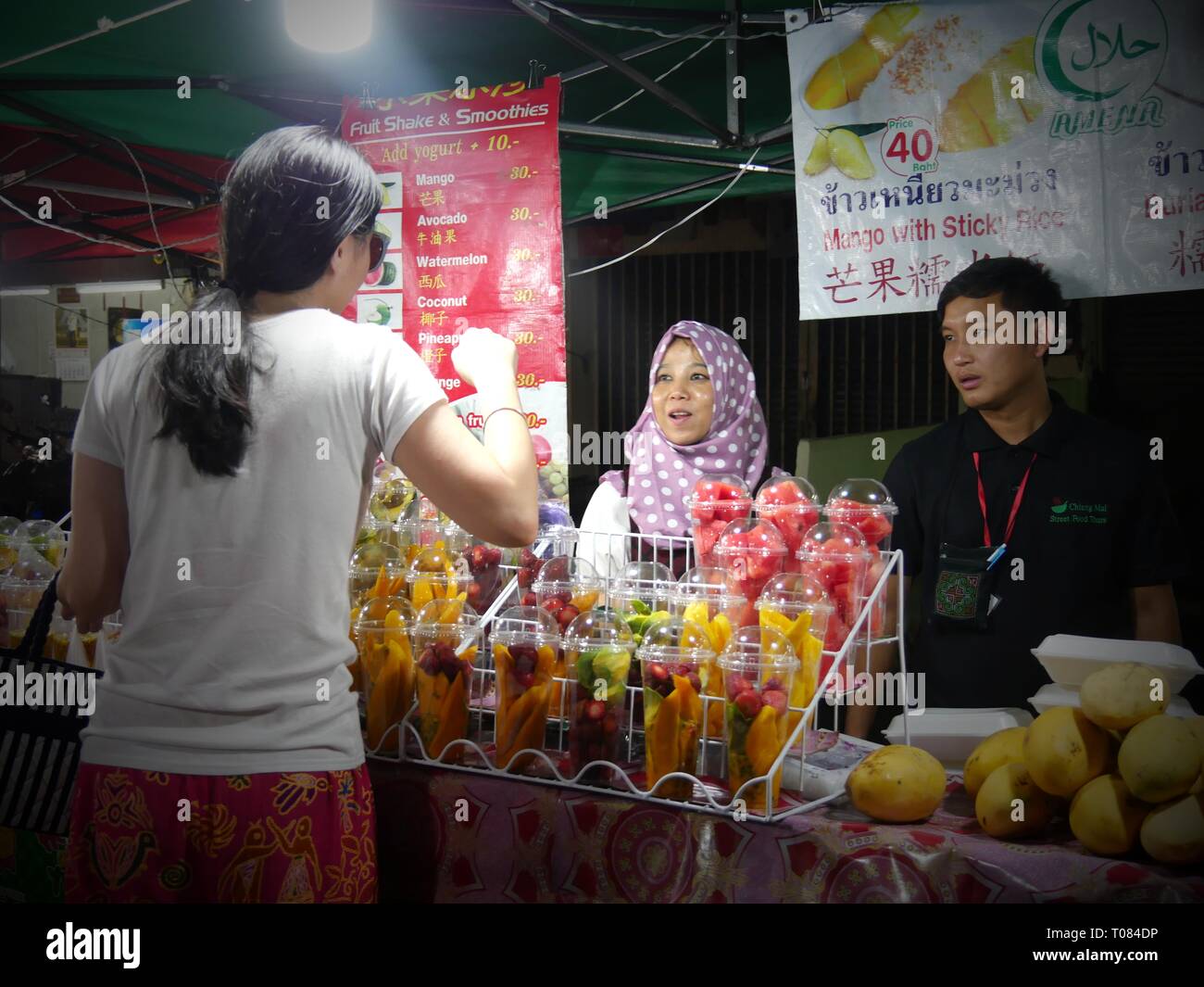CHIANG MAI, THAILAND—MARCH 2018 A customer buys fresh sliced fruit at