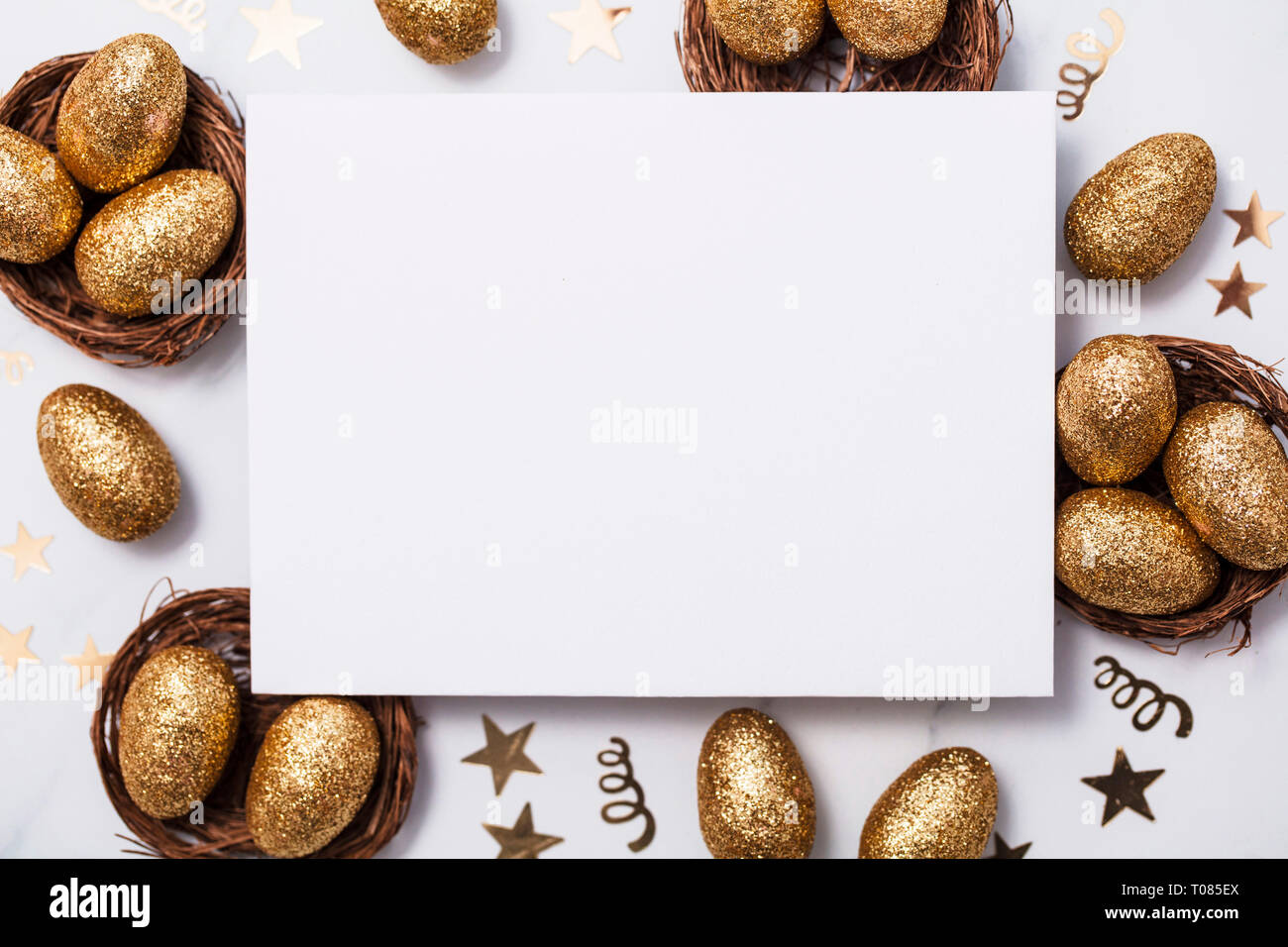 Easter composition. Blank card with gold eggs and nests Stock Photo
