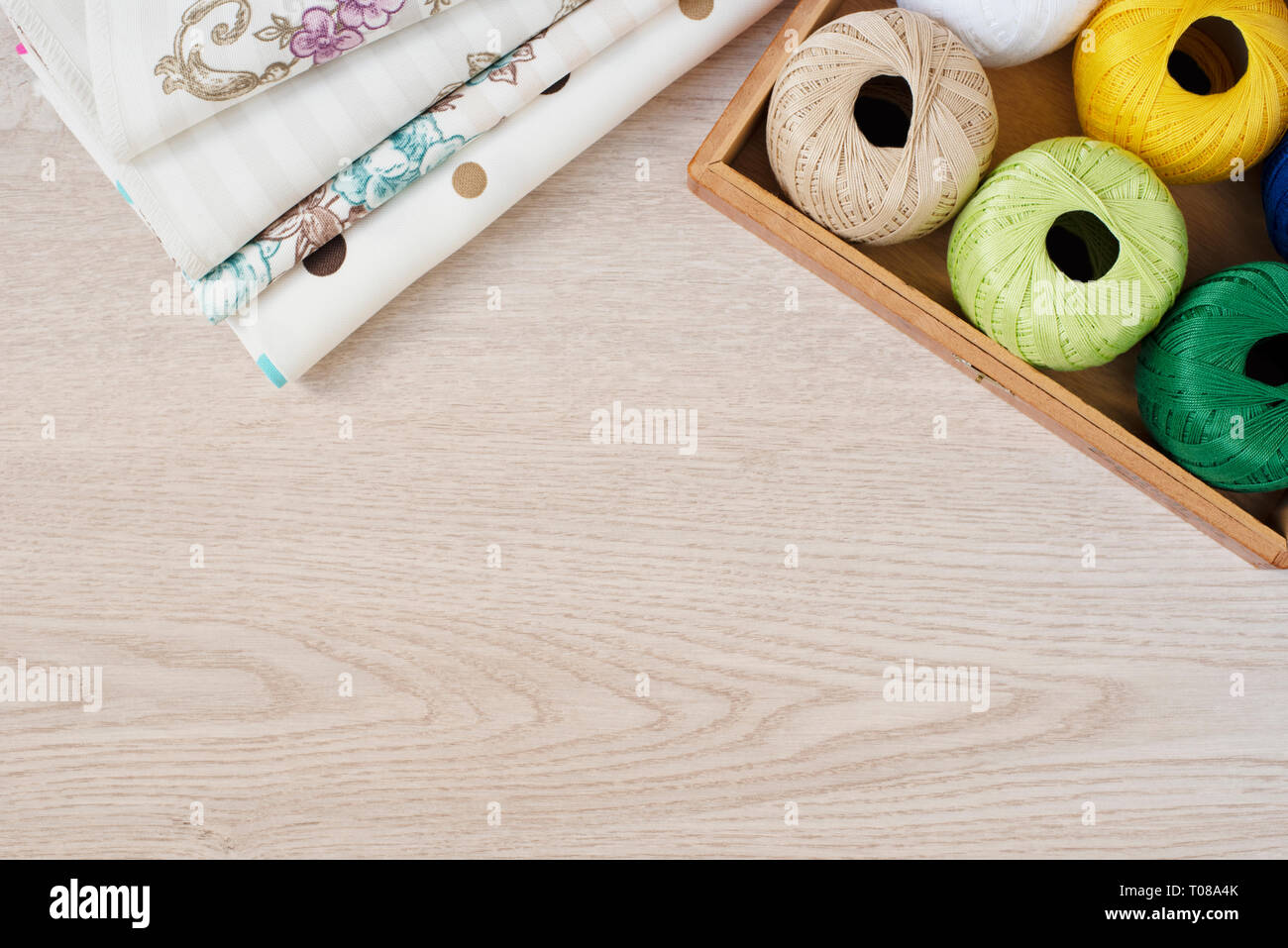 Composition with sewing, knitting threads and fabrics on gray wooden background, top view Stock Photo
