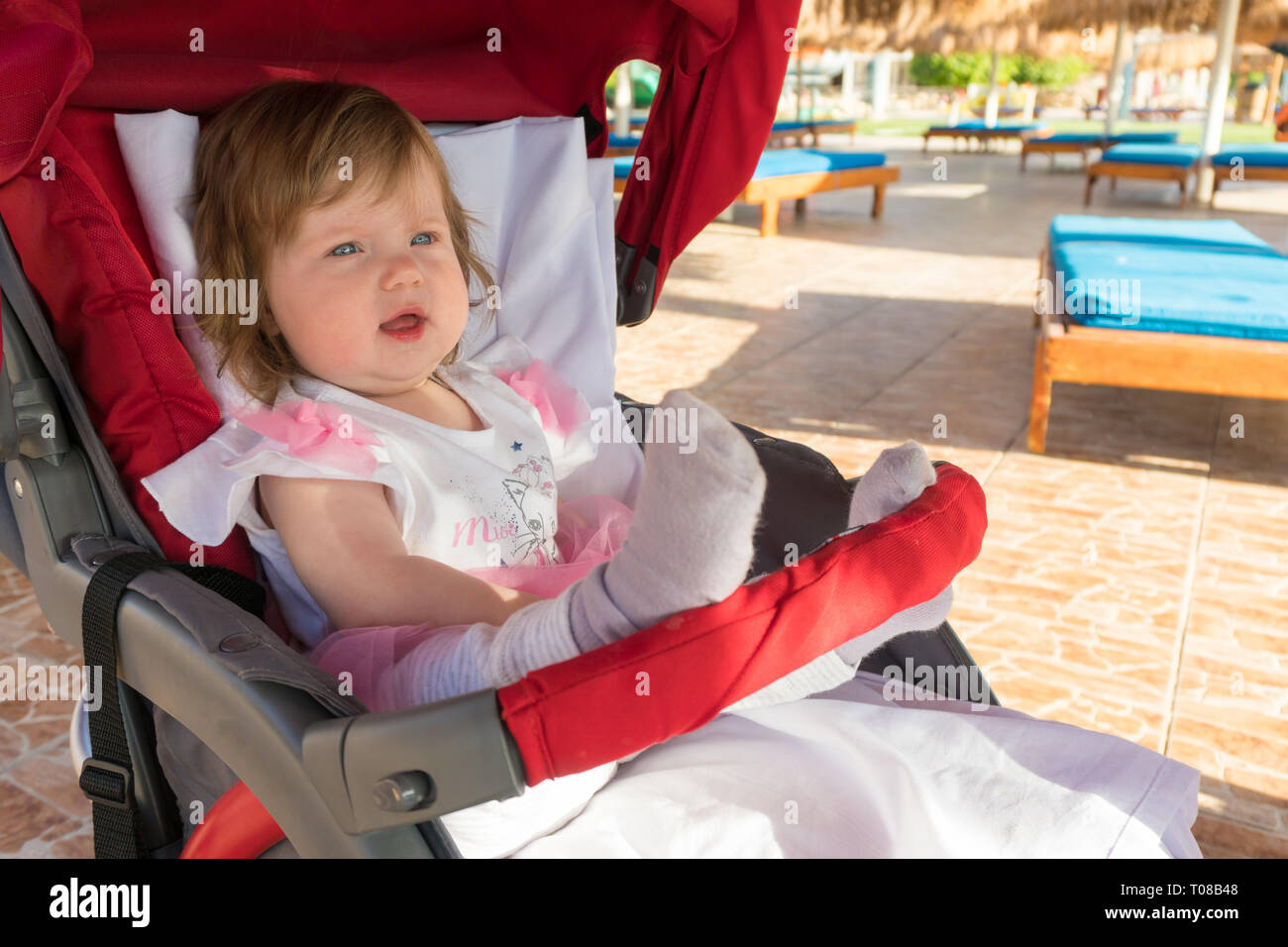 Amazed baby in carriage on resort on the beach Stock Photo