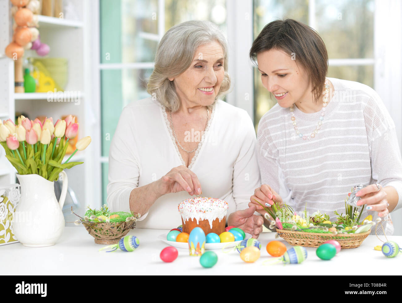 Portrait of mother and daughter colouring eggs Stock Photo