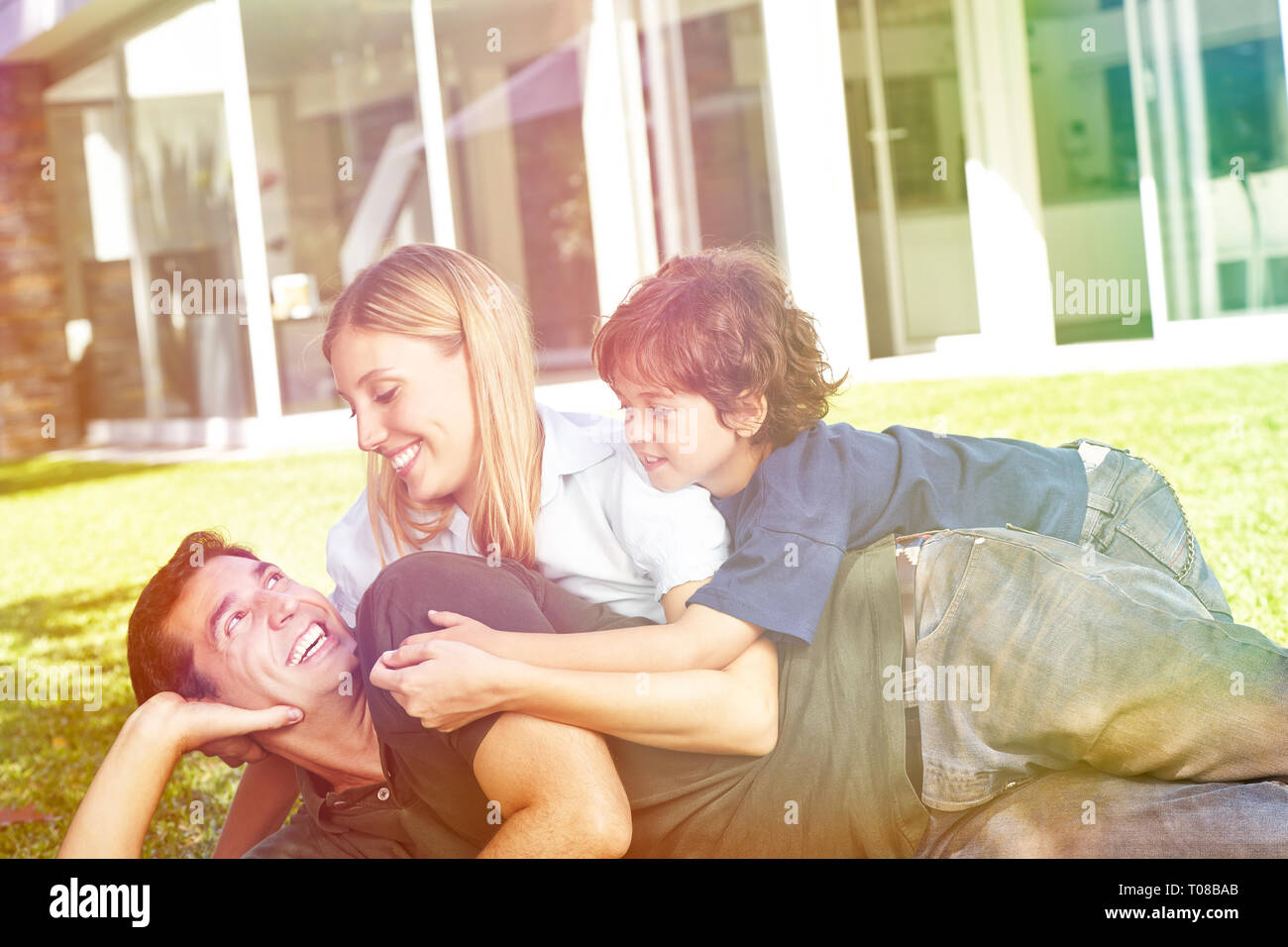 Happy family is lying with a child in the garden from home Stock Photo ...