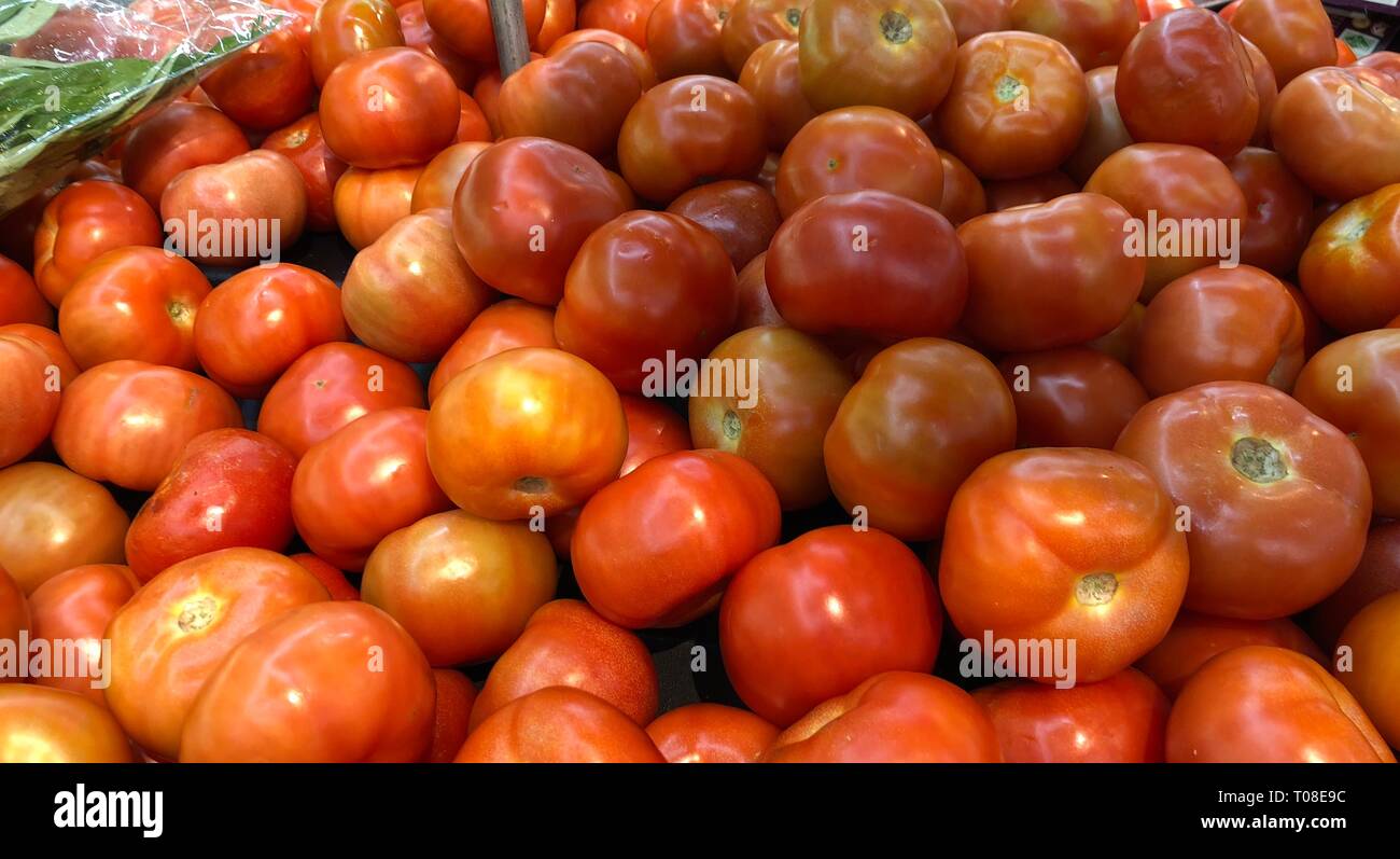 Pile of red and orange tomatoes for sale at a vegetable stall Stock ...