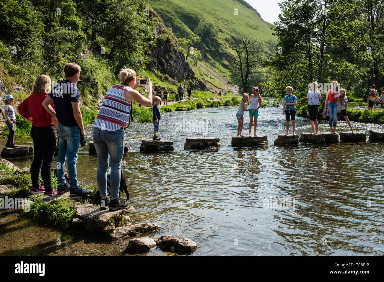 Children having their photo taken at the Stepping Stones, Dovedale, Peak District National Park, Derbyshire Stock Photo