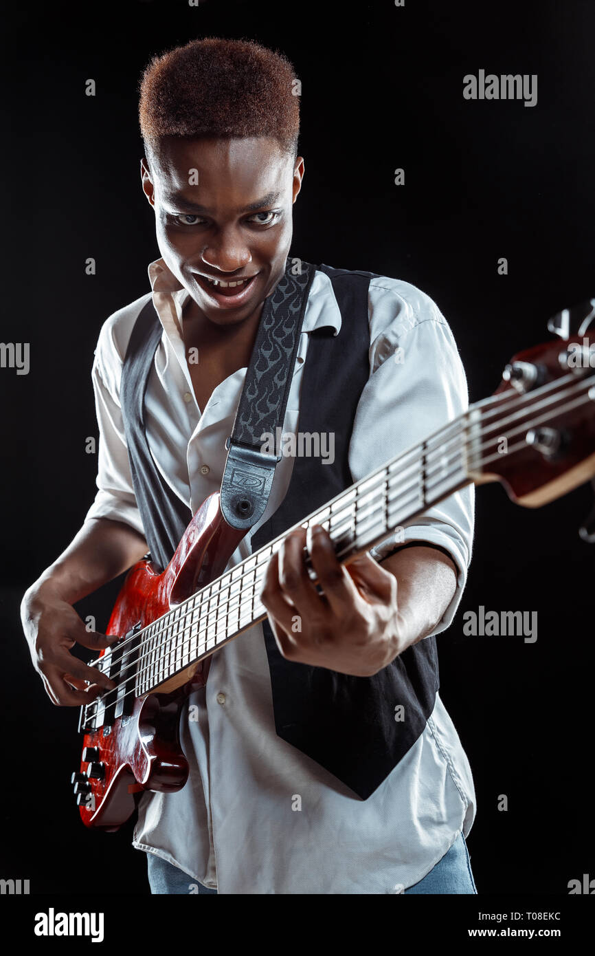 African American handsome jazz musician playing bass guitar in the studio  on a black background. Music concept. Young joyful attractive guy  improvising. Close-up retro portrait Stock Photo - Alamy