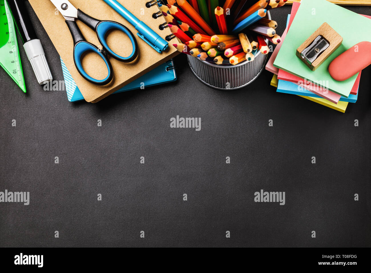 Blackboard with school supplies at the top of the table and copy space ...