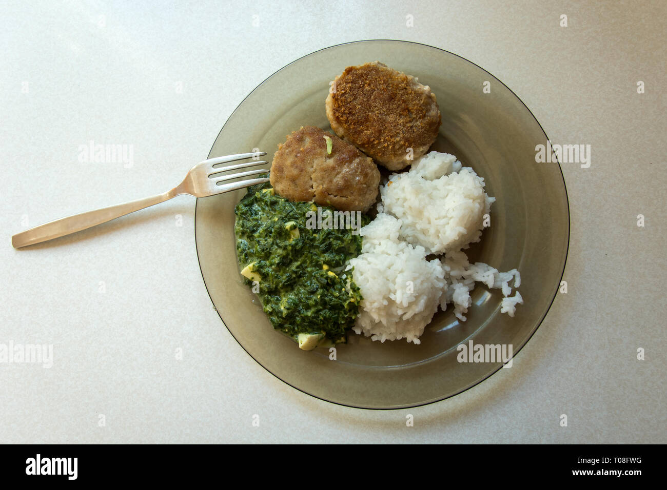 Polish traditional dish on a plate, minced cutlets, rice and spinach - top view Stock Photo
