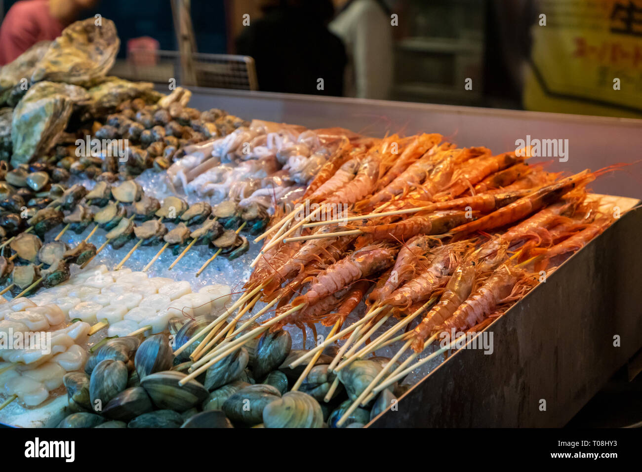 shrimps, oysters, scallops, shellfish and fresh seafood in street food stall in Asian night market Stock Photo
