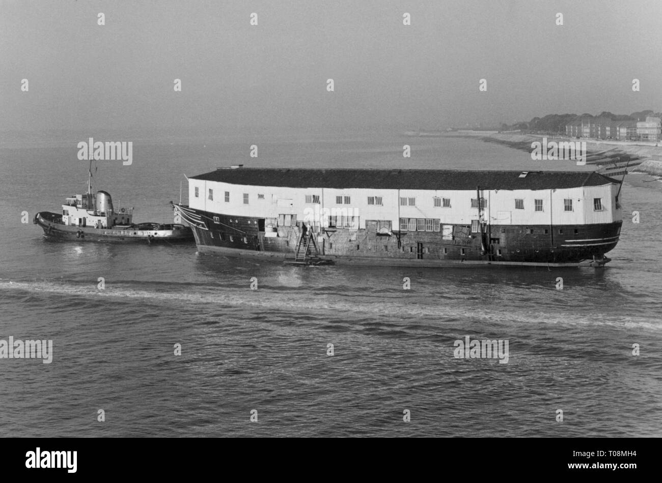 AJAXNETPHOTO. 1971. PORTSMOUTH, ENGLAND. - VETERAN DEPARTS - THE HULK OF EX HMS GANNET (EX GANNET, EX T.S.MERCURY) BEING TOWED OUT OF THE NAVAL BASE AFTER A SHORT REFIT.  PHOTO:JONATHAN EASTLAND/AJAX REF:711912 Stock Photo