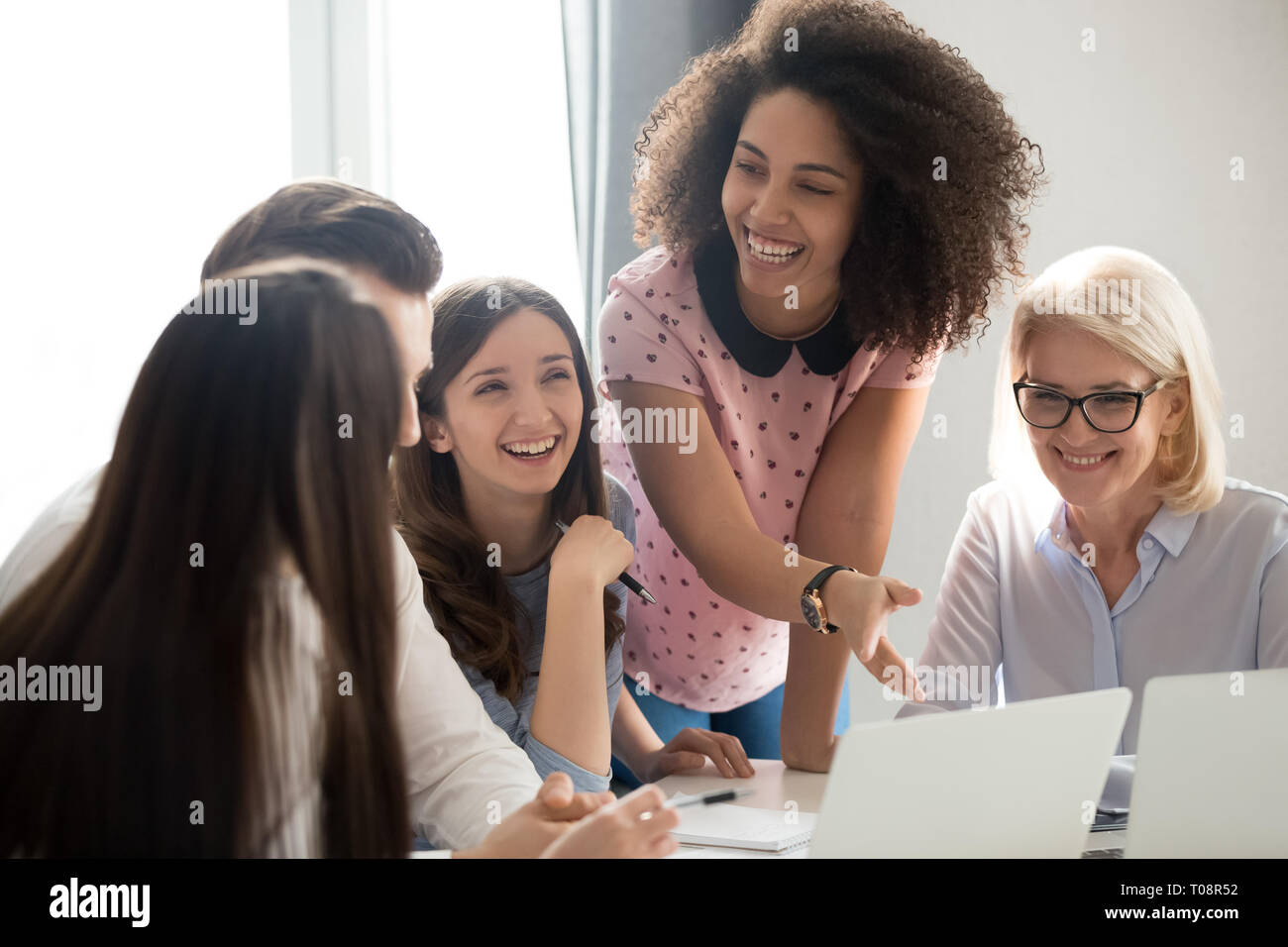 Positive friendly diverse team employees talking laughing at company meeting Stock Photo