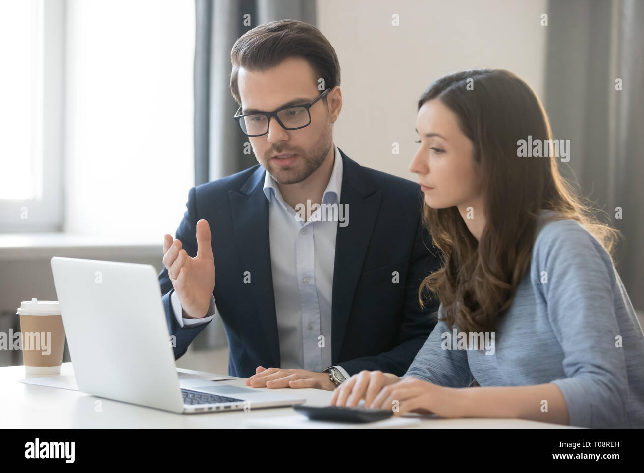 Helpful boss mentor explaining new online project to worker intern Stock Photo