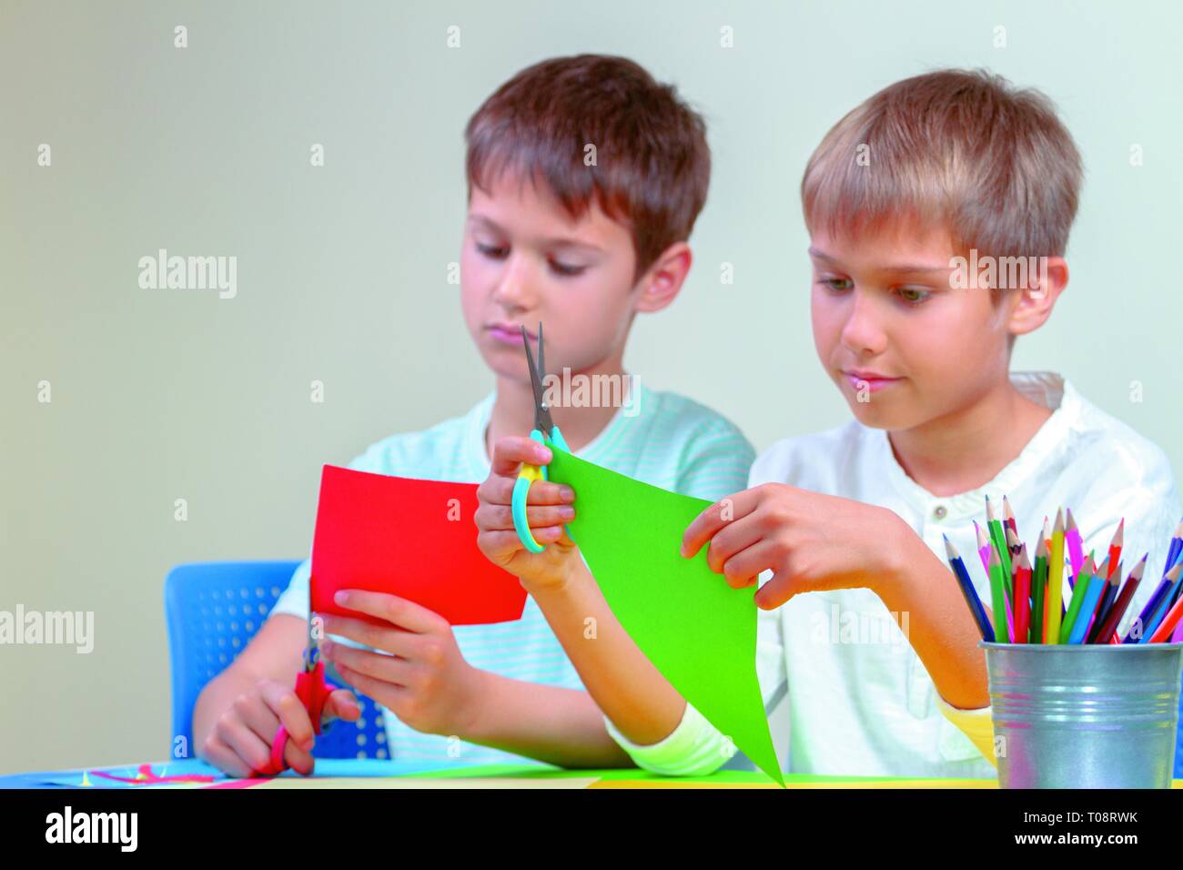 Children Cutting Colored Paper with Scissors at the Table Stock Photo -  Image of children, holding: 141799622
