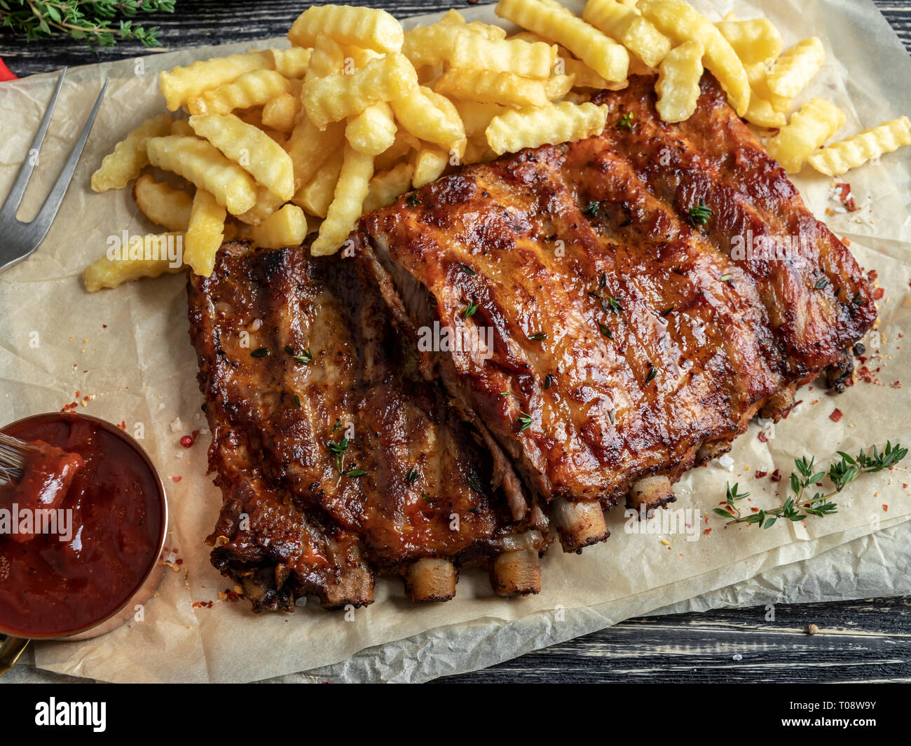 grilled pork ribs with sauce , french fries, spices, wooden background Stock Photo