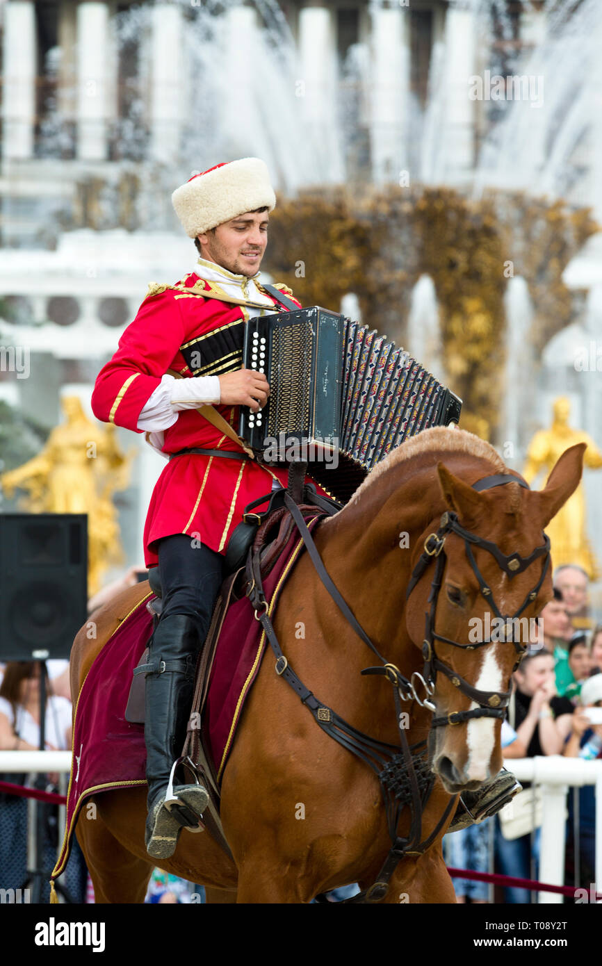 Cossack with accordion at the demonstrations of the Kremlin riding school at VDNH in Moscow, Russia Stock Photo