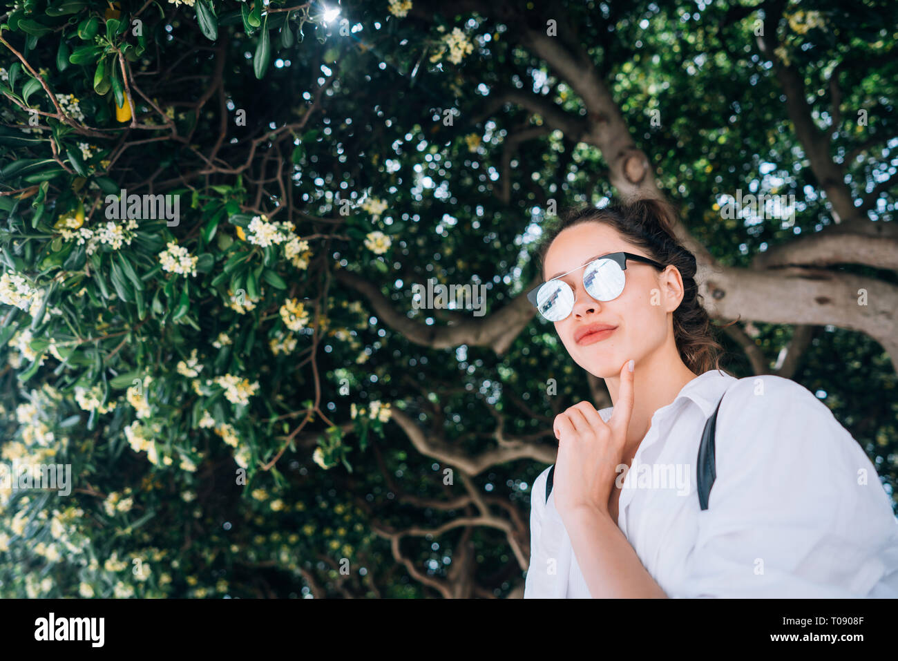 beautiful young girl posing on the background of evergreen tree Stock ...