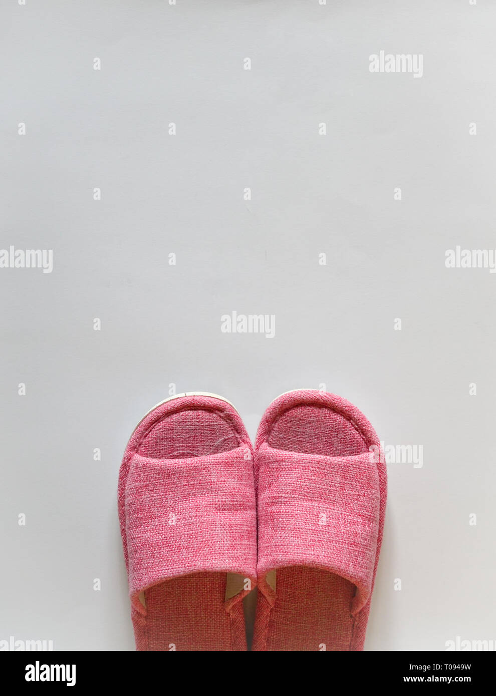 Comfort and cosy concept: a pair of indoor pink sandals on white background with copy space Stock Photo