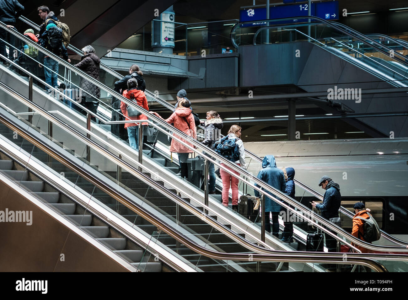 Berlin, Germany - march 2019: People with luggage on escalator inside   train station (Hauptbahnhof) in Berlin Stock Photo