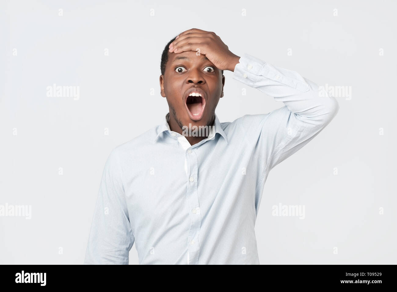 Shocked black male says wow, looks bugged eyes and rounded mouth, being amazed Stock Photo