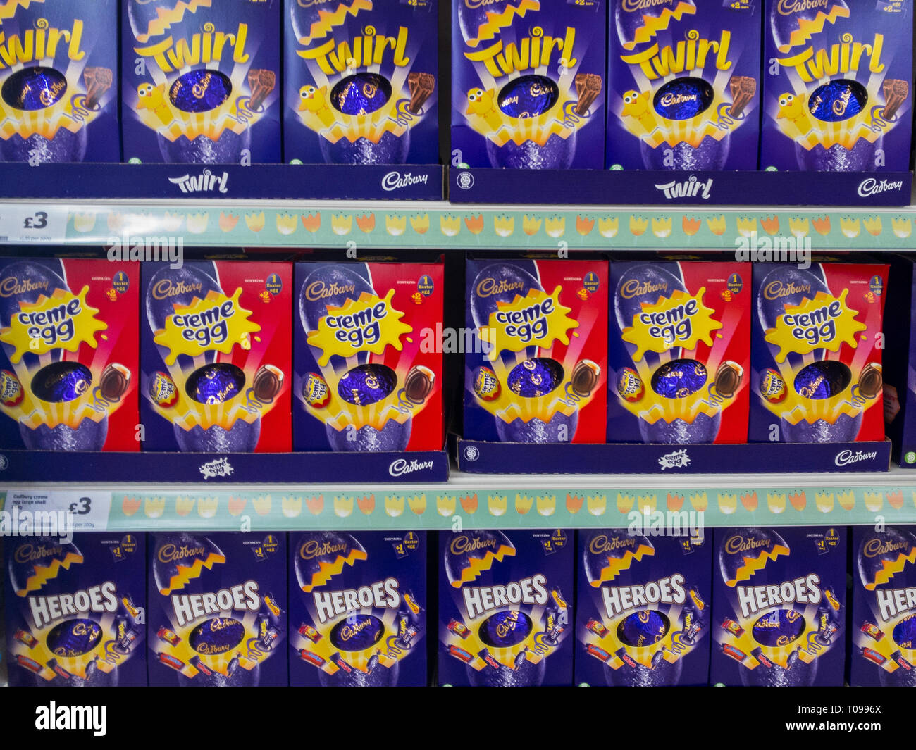 Exeter, Devon , England, March, 14, 2019: A UK supermarket filled shelves selling chocolate Easter Eggs. Lots of purple and red in the image, horizont Stock Photo