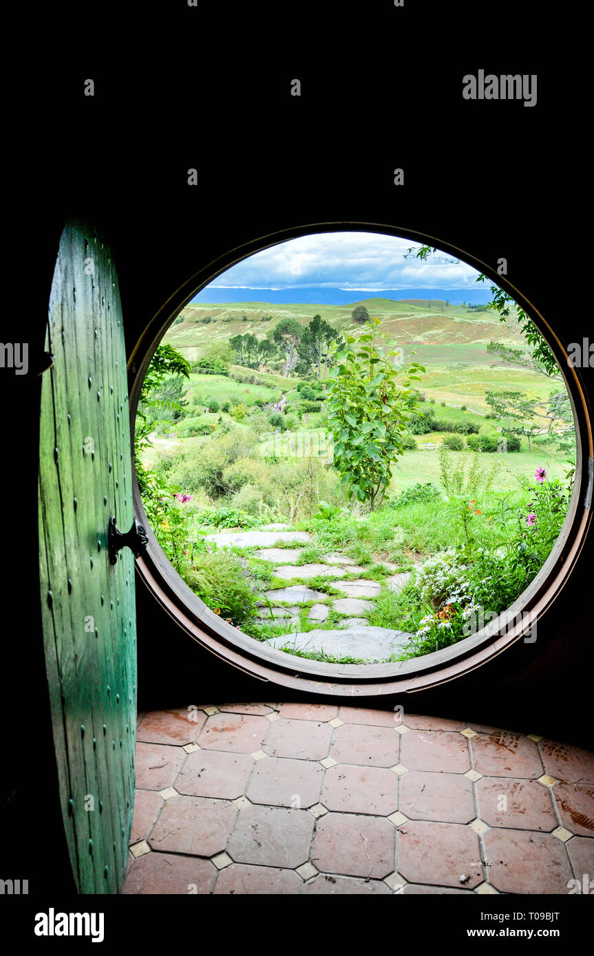 Open circular door of Hobbit Hole at Hobbiton movie set in the Waikato region of New Zealand north island. Looking out to The Shire countryside Stock Photo