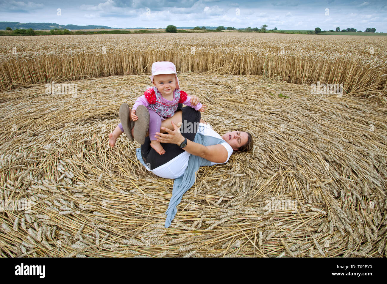 Great Britain, England, Gloucestershire.  Mother and baby enjoy a crop circle formation on the Severn Estuary, July 2010. MR. Stock Photo