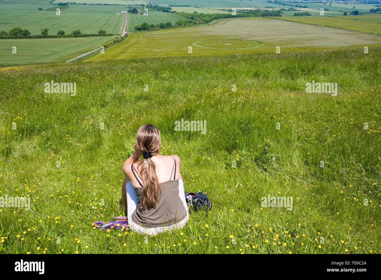 Great Britain, England, Wiltshire.  A visitor views a large 2008 crop circle in Barley below Barbury Castle, known as the Pi circle. Stock Photo