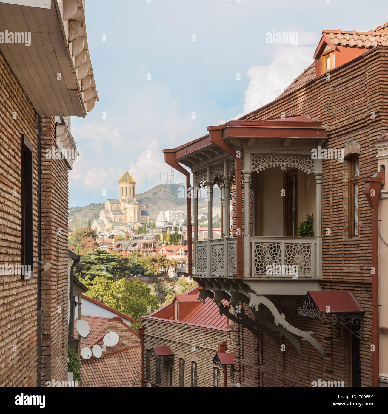 Scenery view of old city Tbilisi, narrow steep street coming down from hill overlooking the Cathedral of Holy Trinity Stock Photo