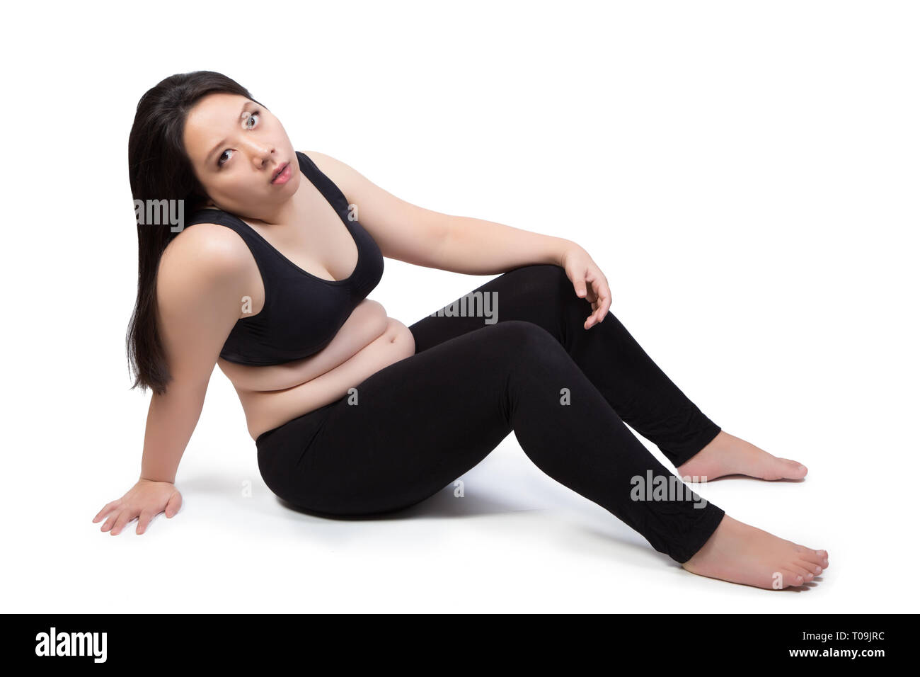 lazy fat woman bored face tired exhausted to exercise weight loss sitting on ground isolated on white background Stock Photo