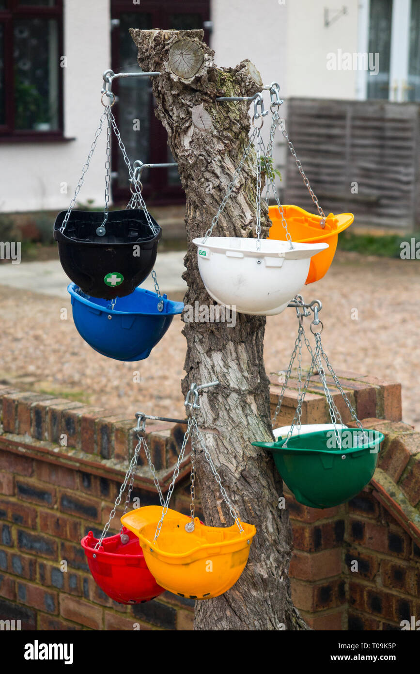 Several hanging baskets together, to decorate / use / disguise a dead tree stump; the hanging
