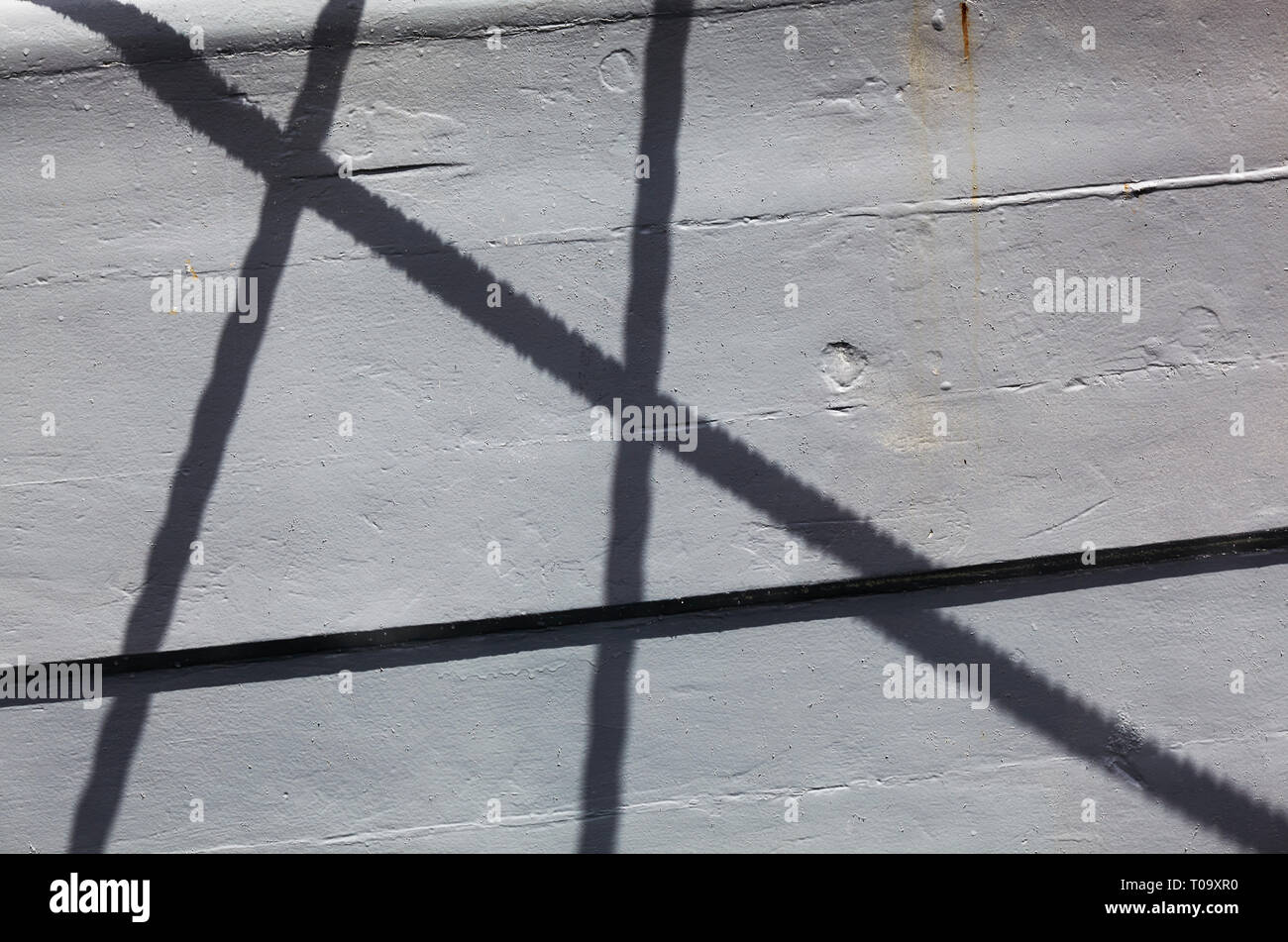 Shadow pattern of criss-crossing mooring lines on a boat in the harbour at Brixham, Devon, Great Britain. Stock Photo