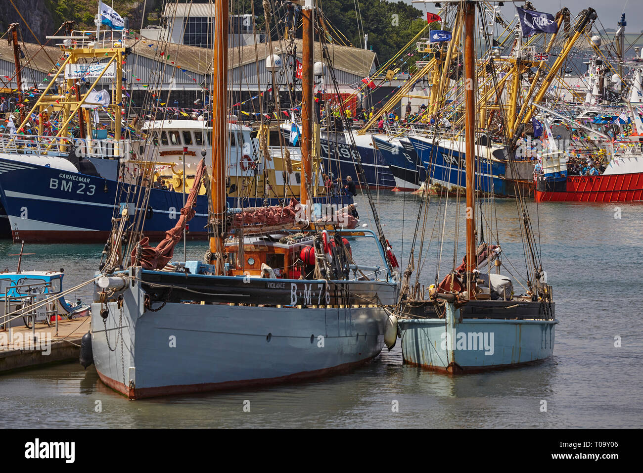 Restored traditional sailing trawlers, with the modern fishing fleet in the background, tied up in the harbour at Brixham, Devon, Great Britain. Stock Photo