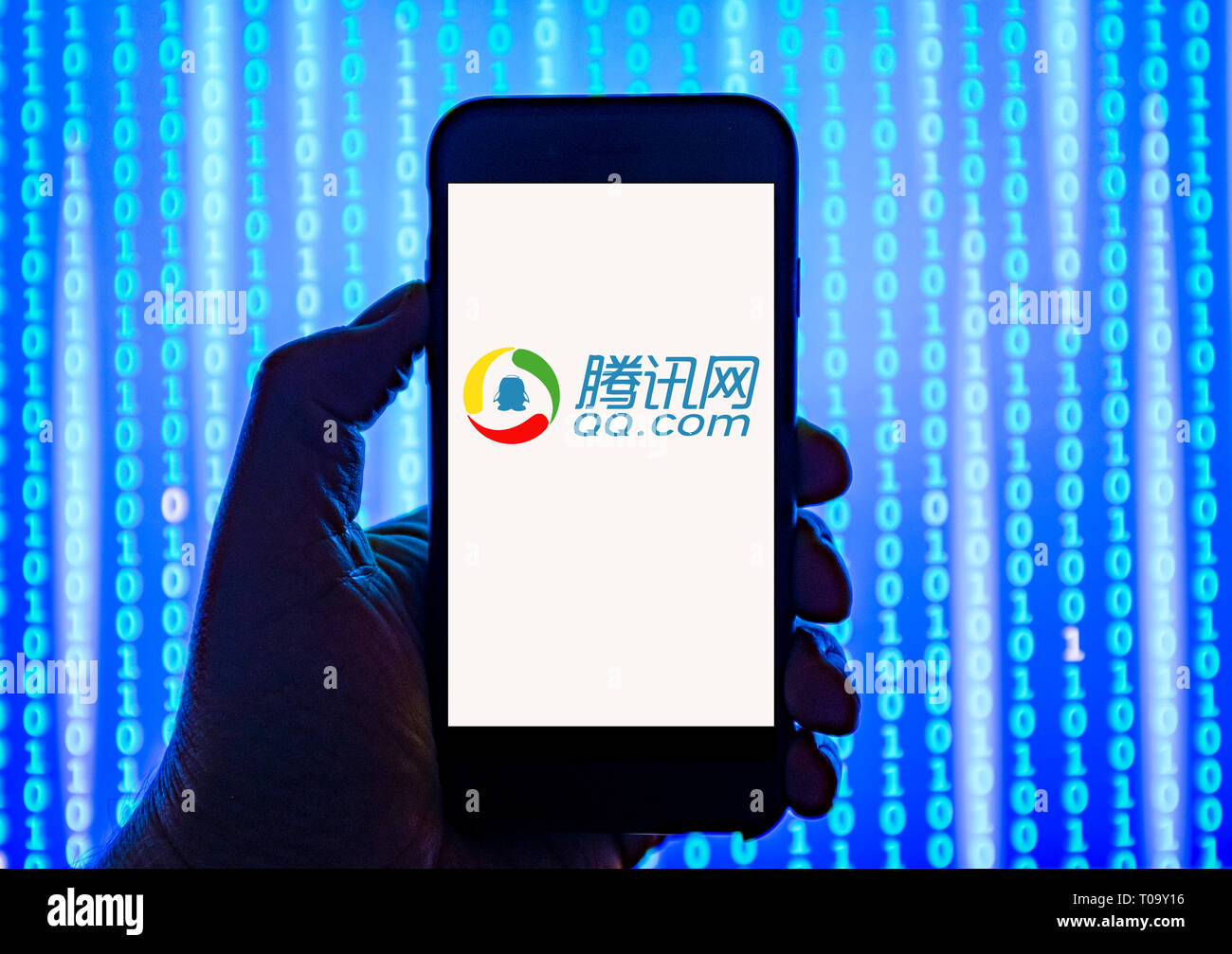 Person holding smart phone with QQ.com   logo displayed on the screen.Tencent QQ, also known as QQ, is an instant messaging software service Stock Photo