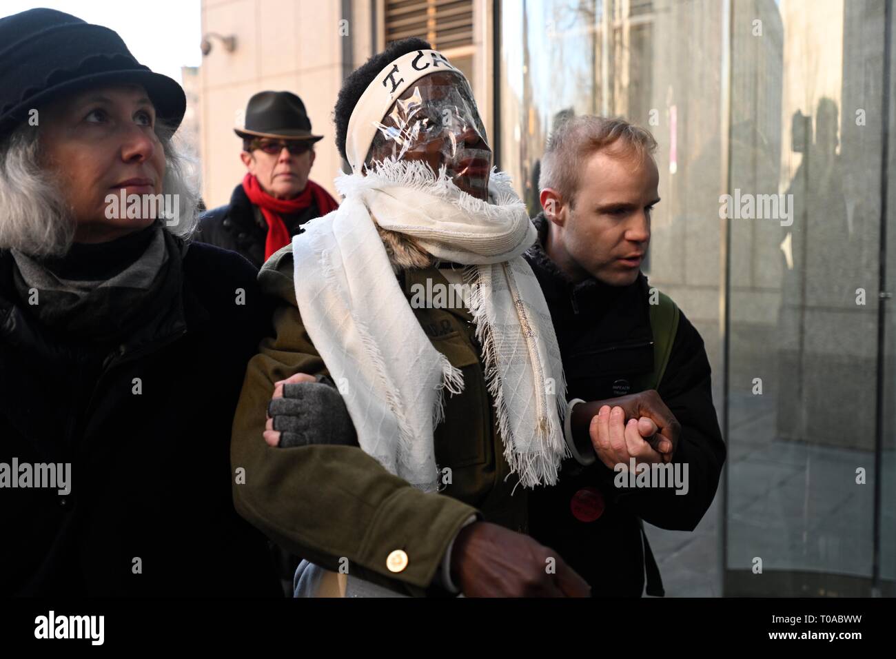 New York, NY, USA. 19th Mar 2019.  Supporters escort Statue of Liberty climber Patricia Okoumou, with clear plastic covering her face, into federal court before her sentencing for her July 4, 2018, act of civil disobedience to protest against Trump administration immigration policies.  Okoumou was convicted in December of misdemeanor charges of trespassing, disorderly conduct, and interfering with the functioning of government. Credit: Joseph Reid/Alamy Live News Stock Photo
