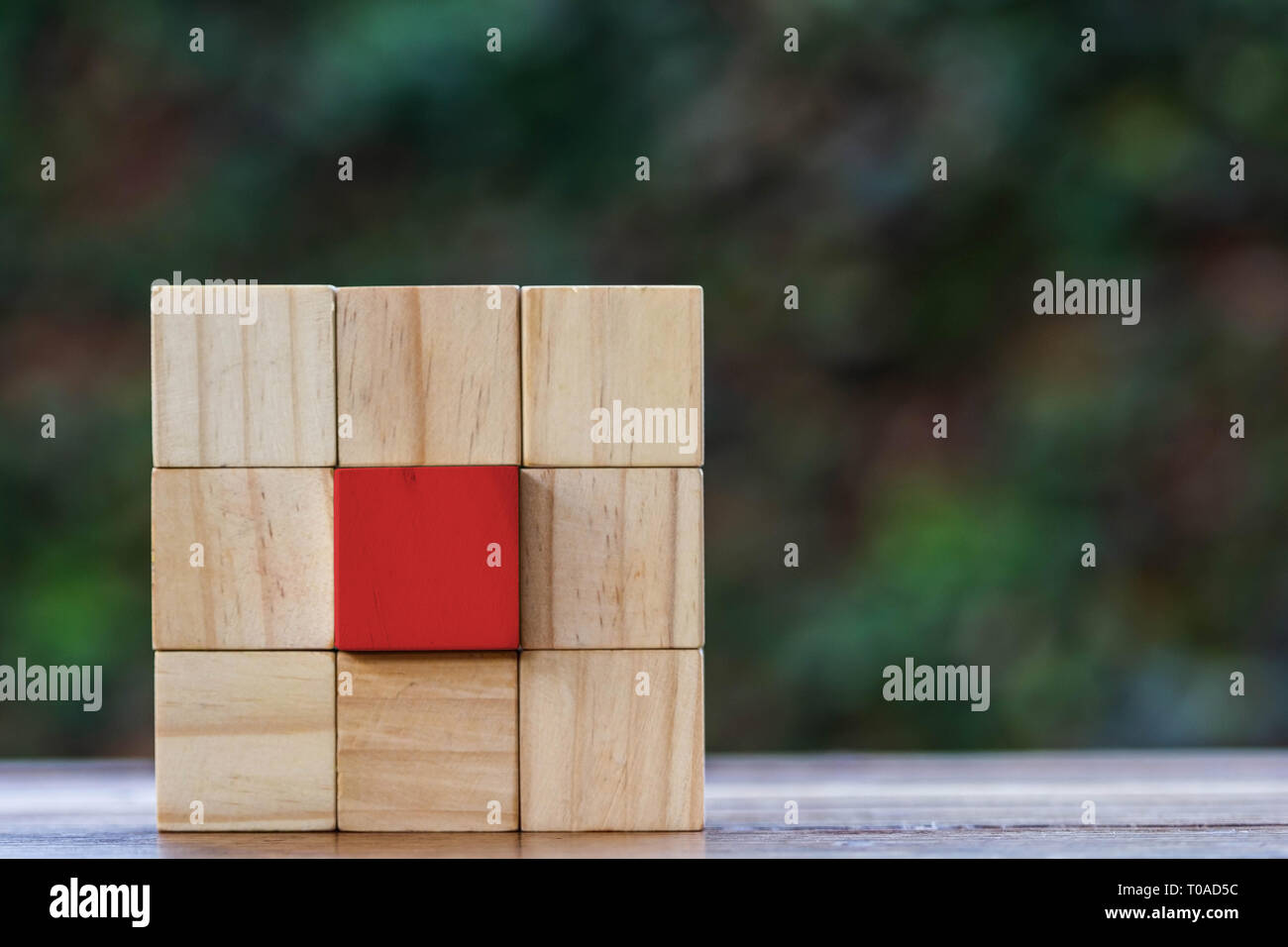 Different thinking concept. Group of wooden block and red wooden block at the center and space right. Depicts business competition, Outstanding, uniqu Stock Photo