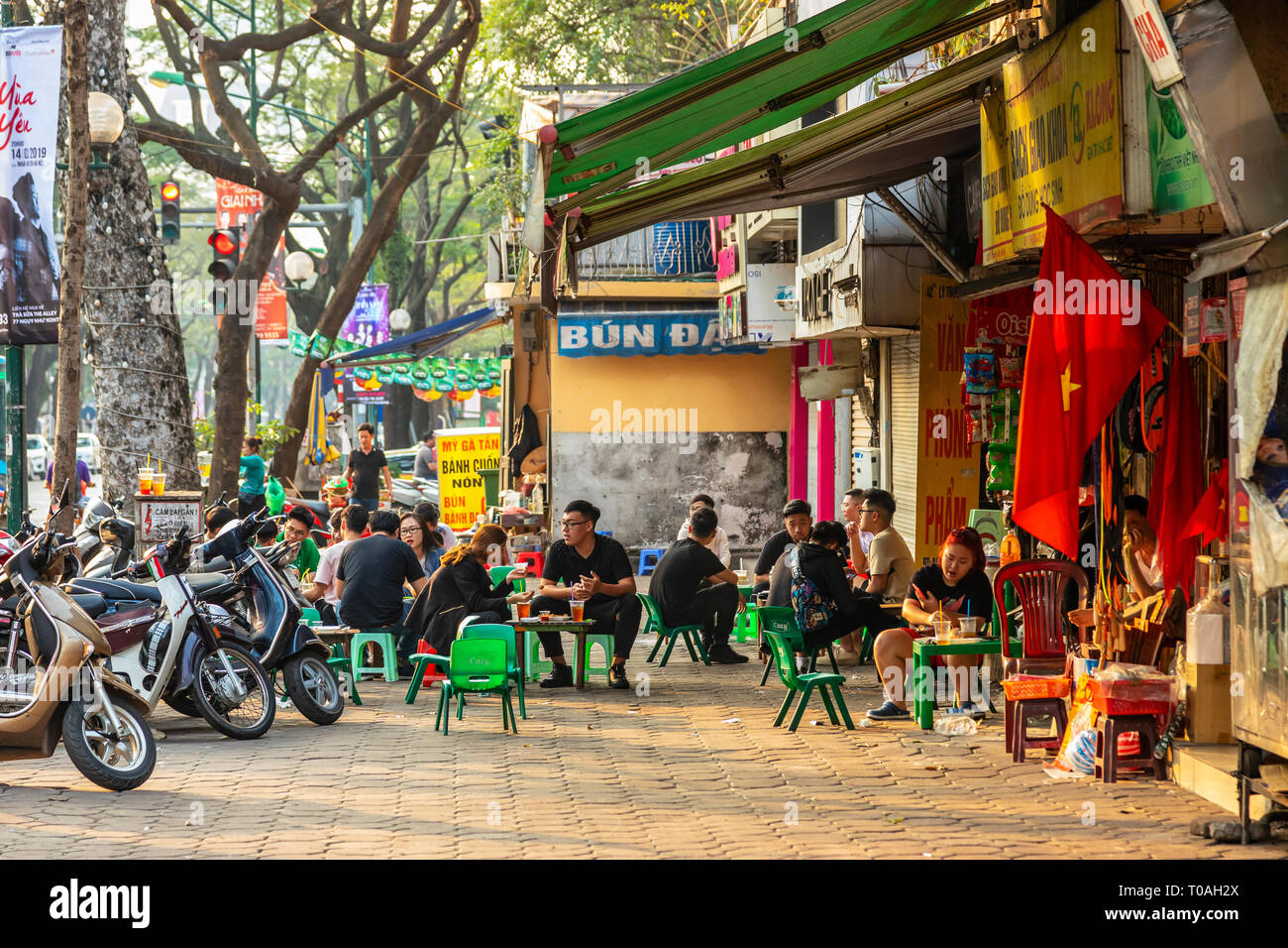 Young students having coffee and drinks at a street cafe, Old Quarter, Hanoi, Vietnam, Asia Stock Photo