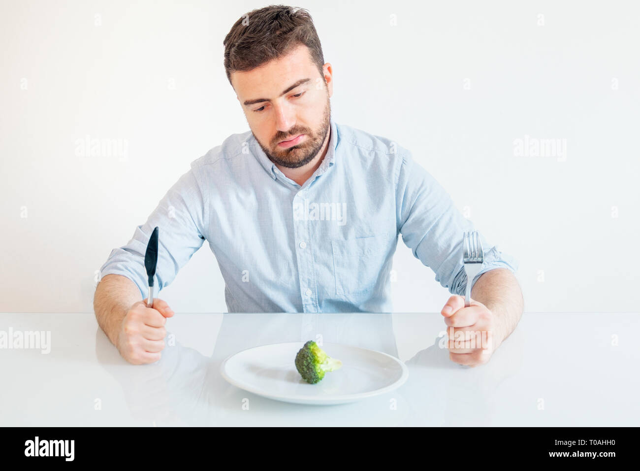 Голодный пустой. Голодный пустой. Голодный пустой. Человек сидит за столом. Мужчина за столом с пустой тарелкой.