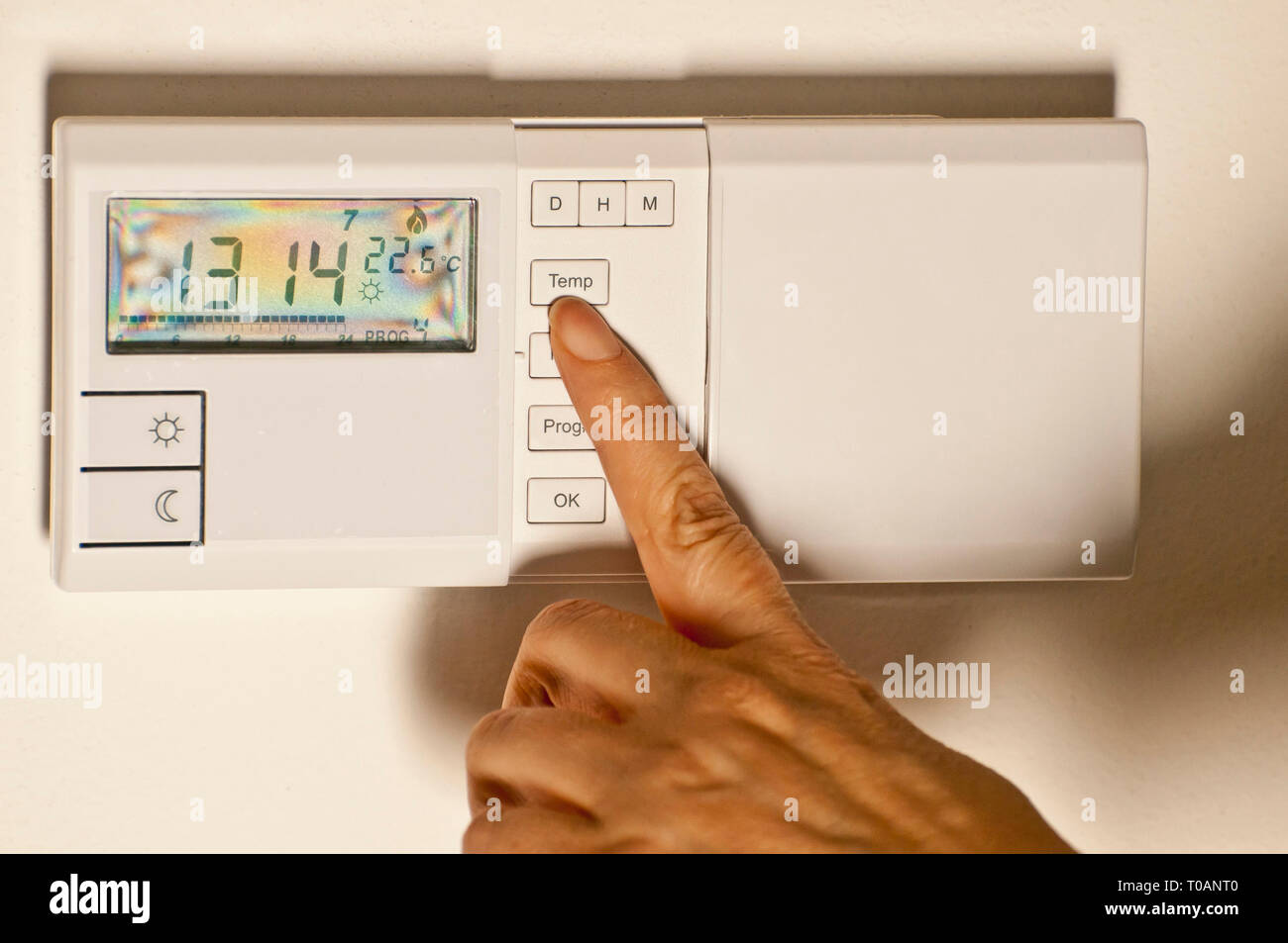 woman hand regulating an home thermostat Stock Photo
