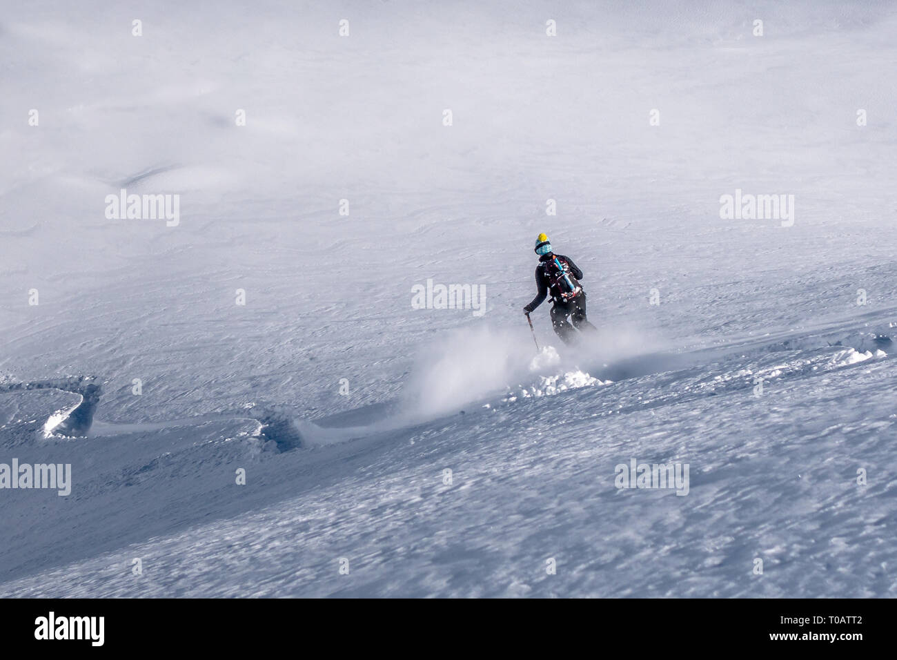 Chamonix, France - 5 February 2019: A female freeride skier descending a slope with fresh powder snow in the Vallon de Berard in the Aiguilles Rouges  Stock Photo