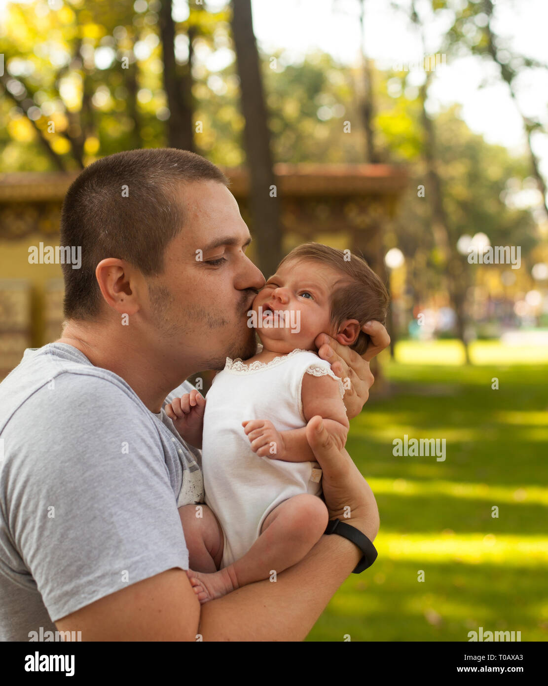 Father holding and kissing newborn little girl Stock Photo