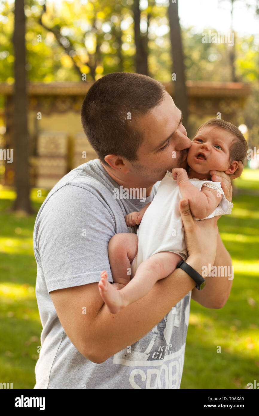 Happy father holding and kissing little newborn daughter Stock Photo