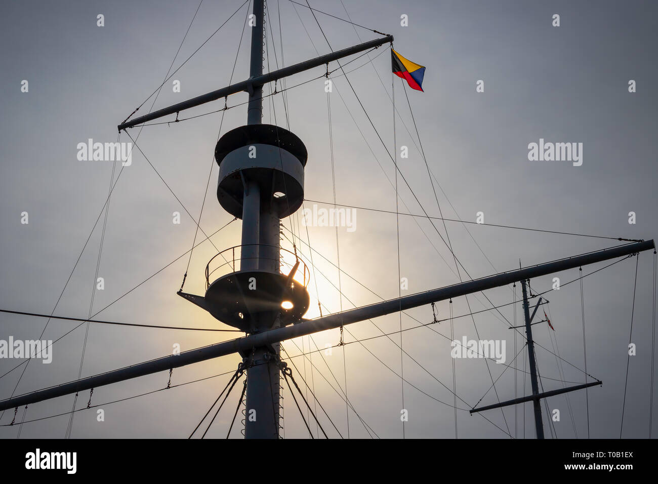 The sun breaking through clouds on the mast of an old sailing ship on Japan’s east coast. Stock Photo