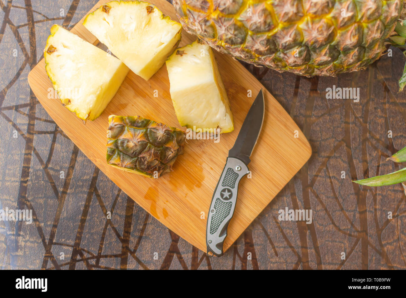 Four pineapple slices kept on a chopping board with a knife and another