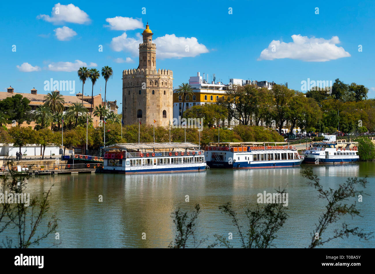 The Tower of Gold (Torre del Oro) beside the tour boat dock of the Guadalquivir River in Seville Stock Photo